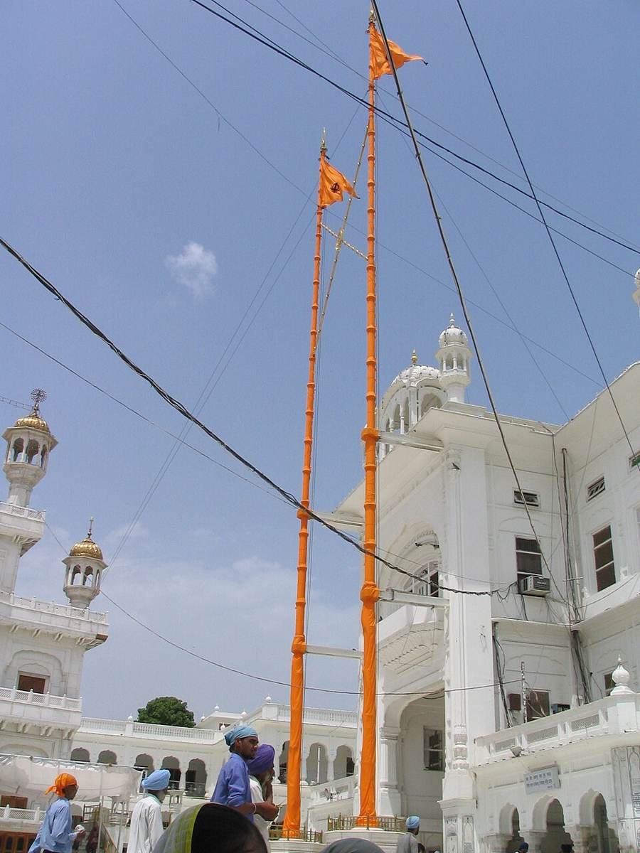 Nishan Sahib flags flying above a Sikh shrine